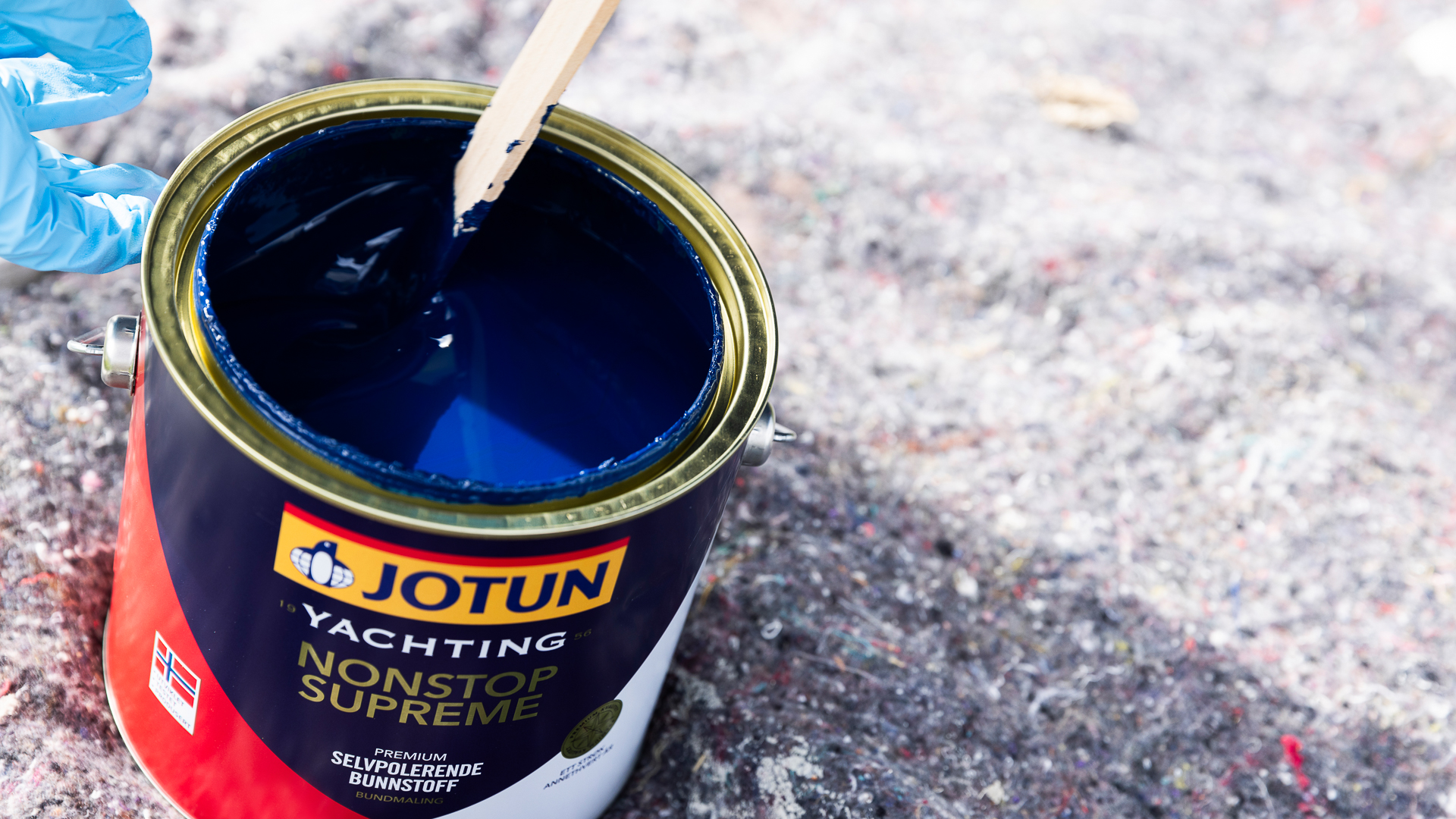 Åpent spann med Jotun Yachting NonStop Supreme bunnstoff for båt med rørepinne i.