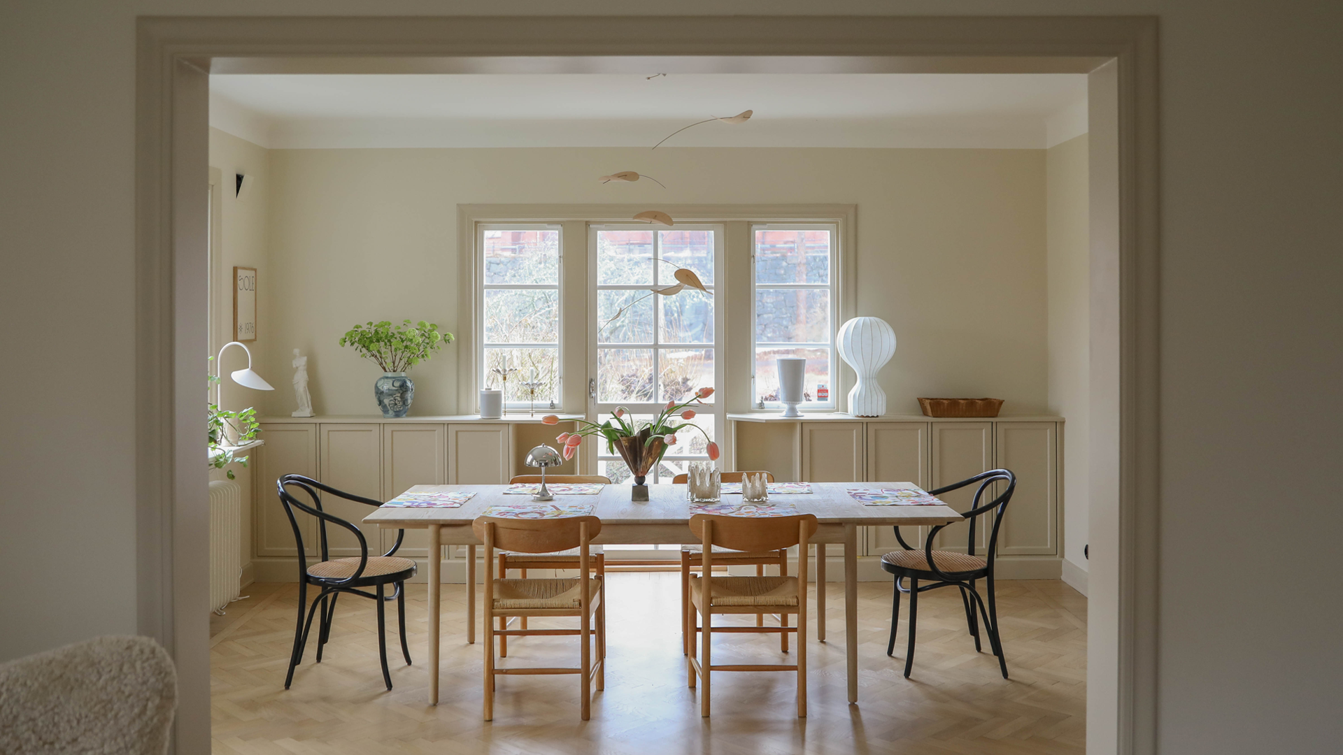 Matbord och stolar i gul matsal. Väggarna är målade med LADY Pure Color i Jotun 12313 Soft Dunes och snickerierna med LADY Supreme Finish Silkematt i Jotun 1303 Observe.