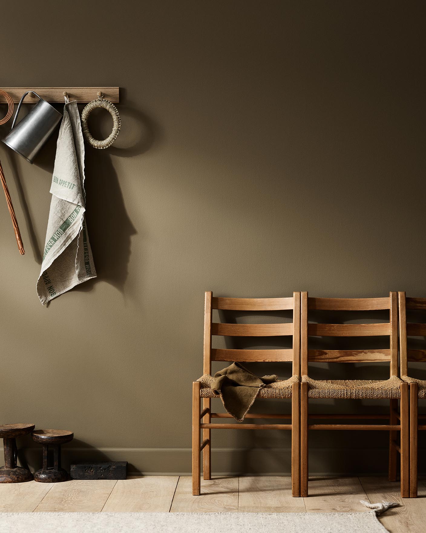 Rustic interior with wooden chairs  against a golden brown wall painted with the Jotun colour 10963 Golden Bronze.