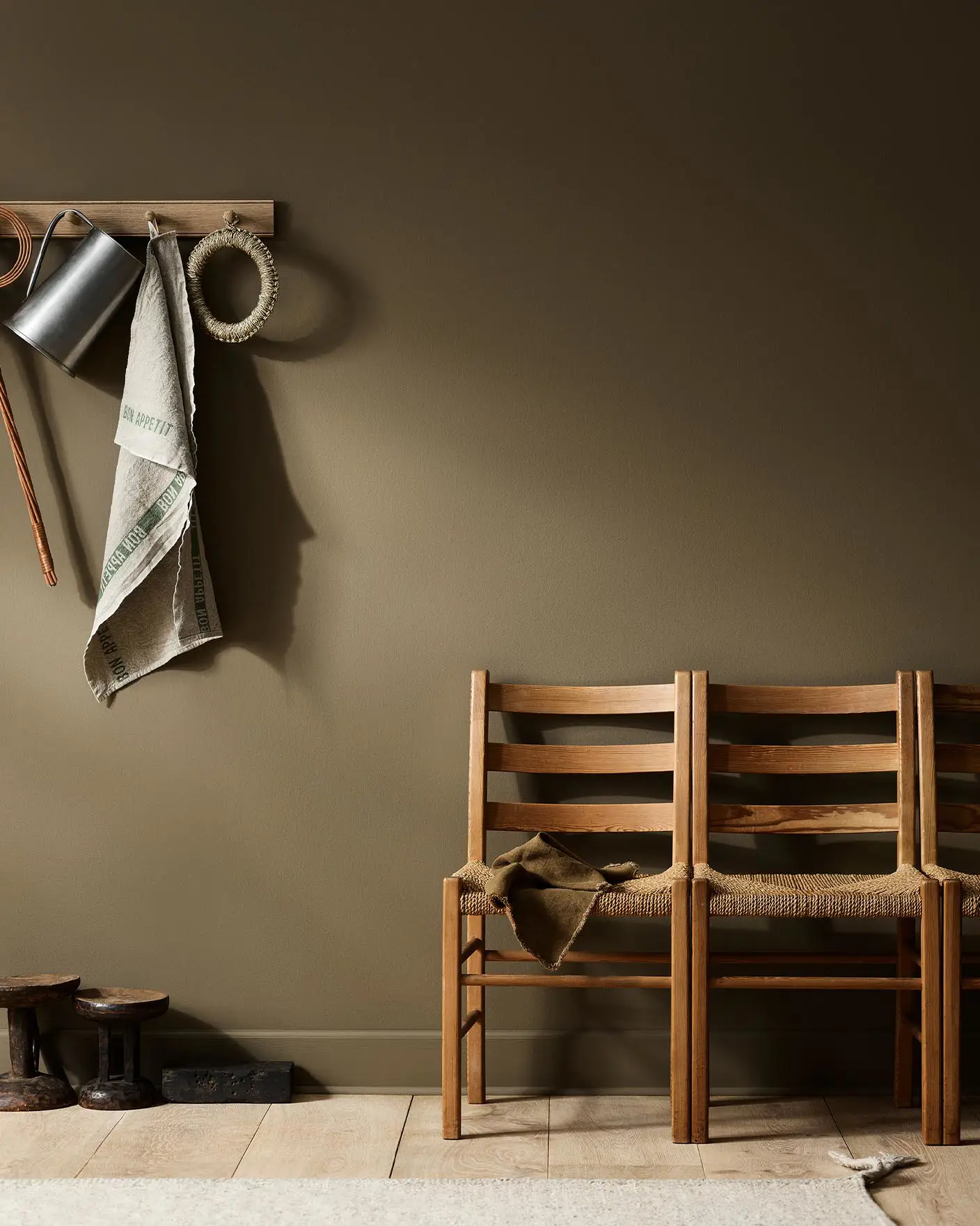 Rustic interior with wooden chairs against a golden brown wall painted with the Jotun colour 10963 Golden Bronze.