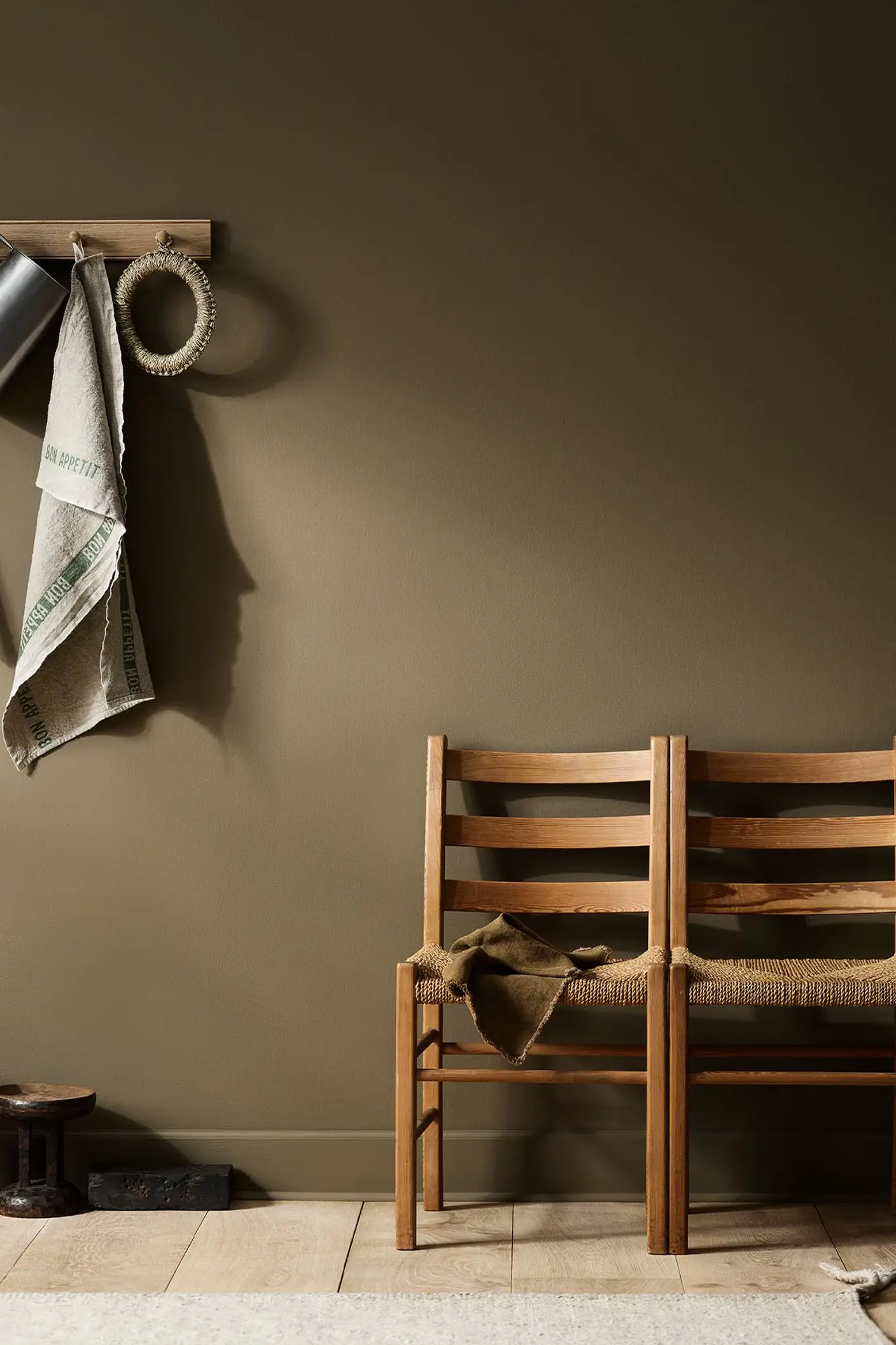 Rustic interior with wooden chairs against a golden brown wall painted with the Jotun colour 10963 Golden Bronze.