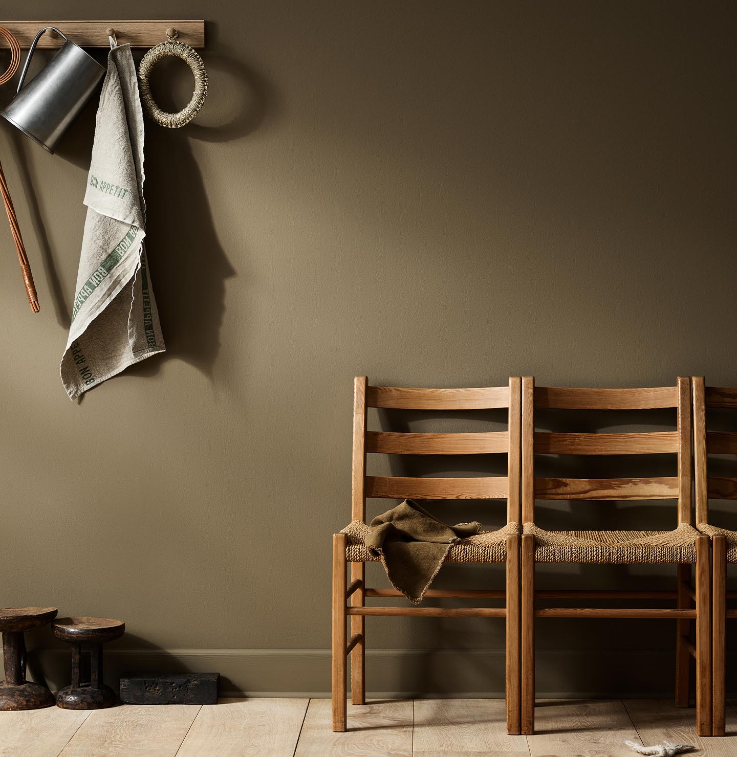 Rustic interior with wooden chairs  against a golden brown wall painted with the Jotun colour 10963 Golden Bronze.