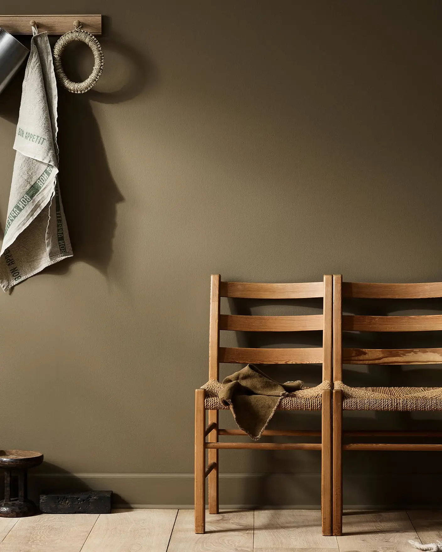 Rustic interior with wooden chairs against a golden brown wall painted with the Jotun colour 10963 Golden Bronze.