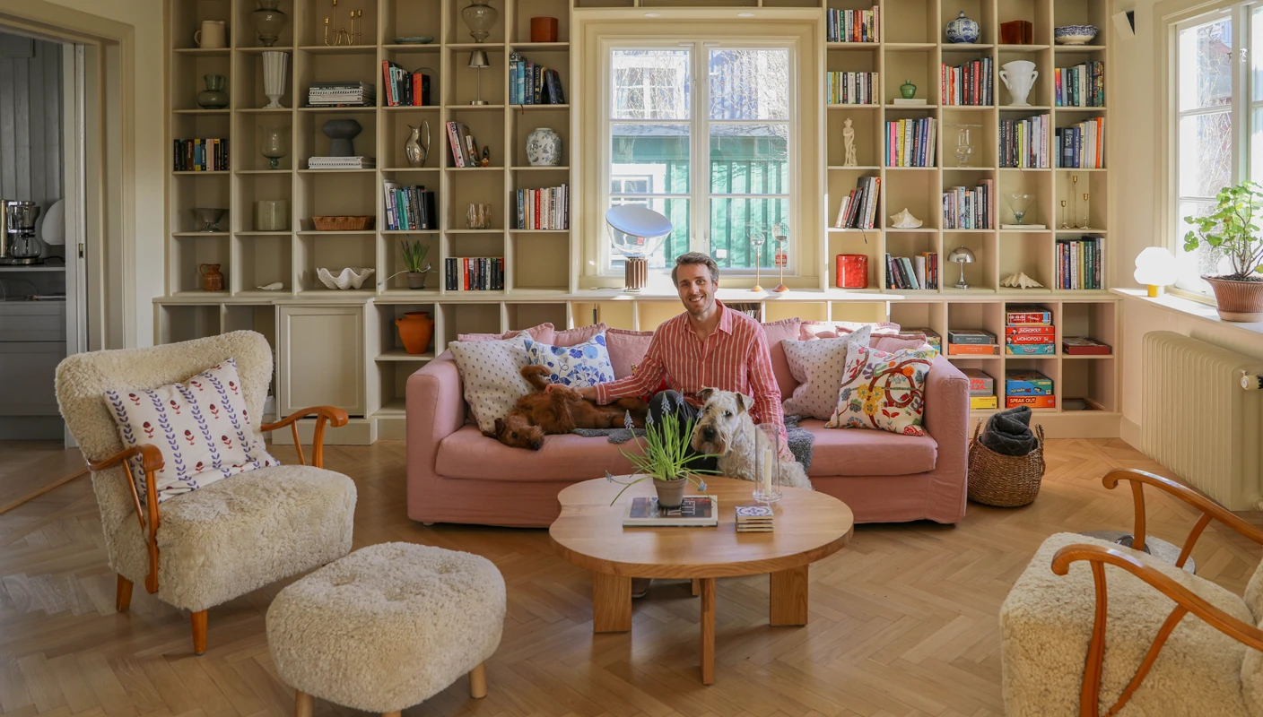 Hannes Mauritzson i rosa soffa framför bokhylla målad med LADY Supreme Finish i Observe