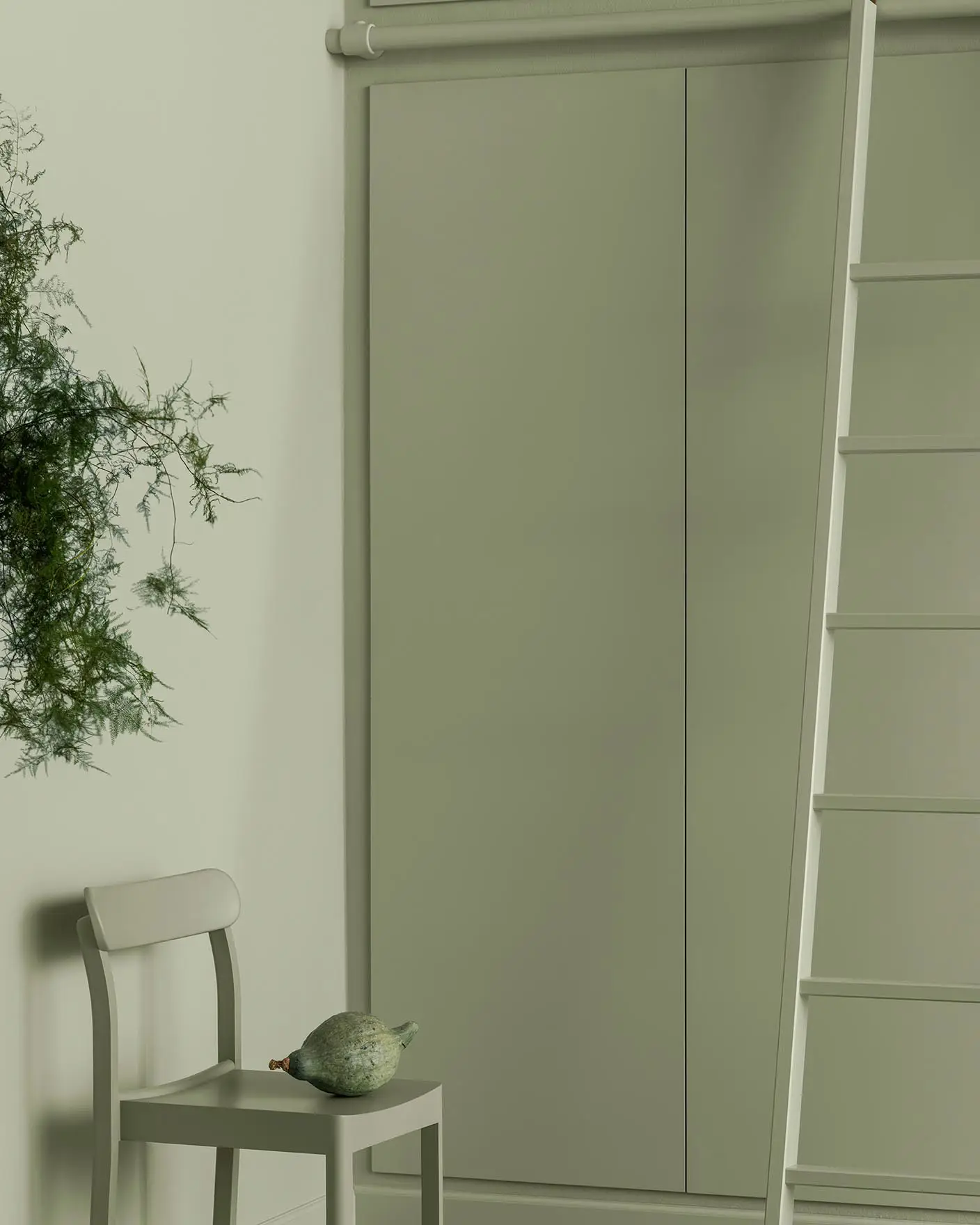 Myke grønnfarger fyller dette rommet med en malt stol, stige og skap som smelter sømløst sammen og skaper et rolig, monokromt uttrykk med et naturlig preg. Alt er malt med fargen 7038 Dusk Green fra Jotun.