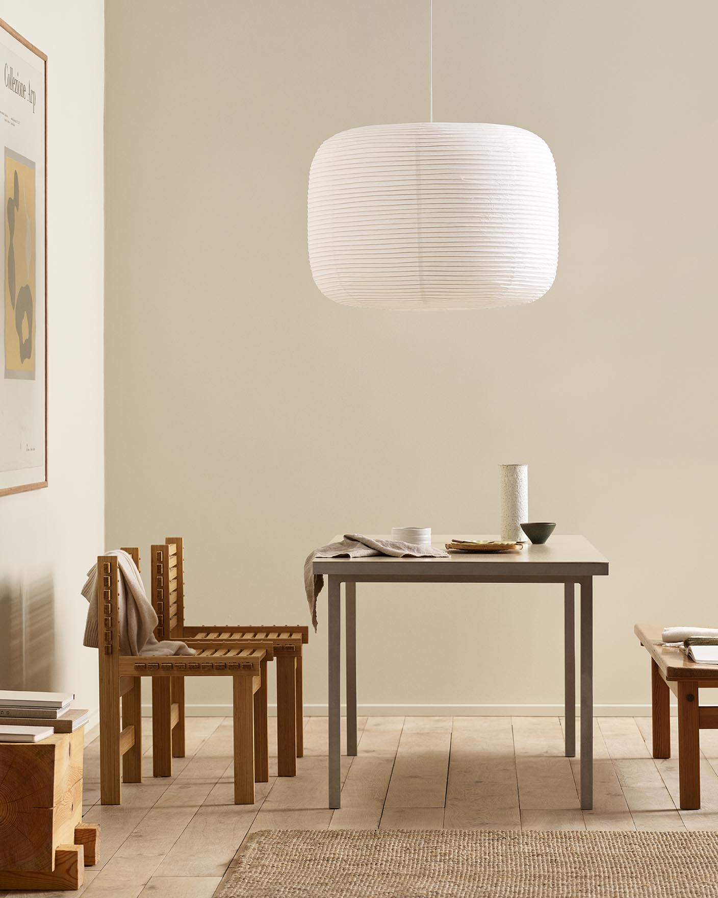 Minimalist dining area with wooden chairs, pendant light, and golden beige walls painted with the colour 12308 Unbleached from Jotun.