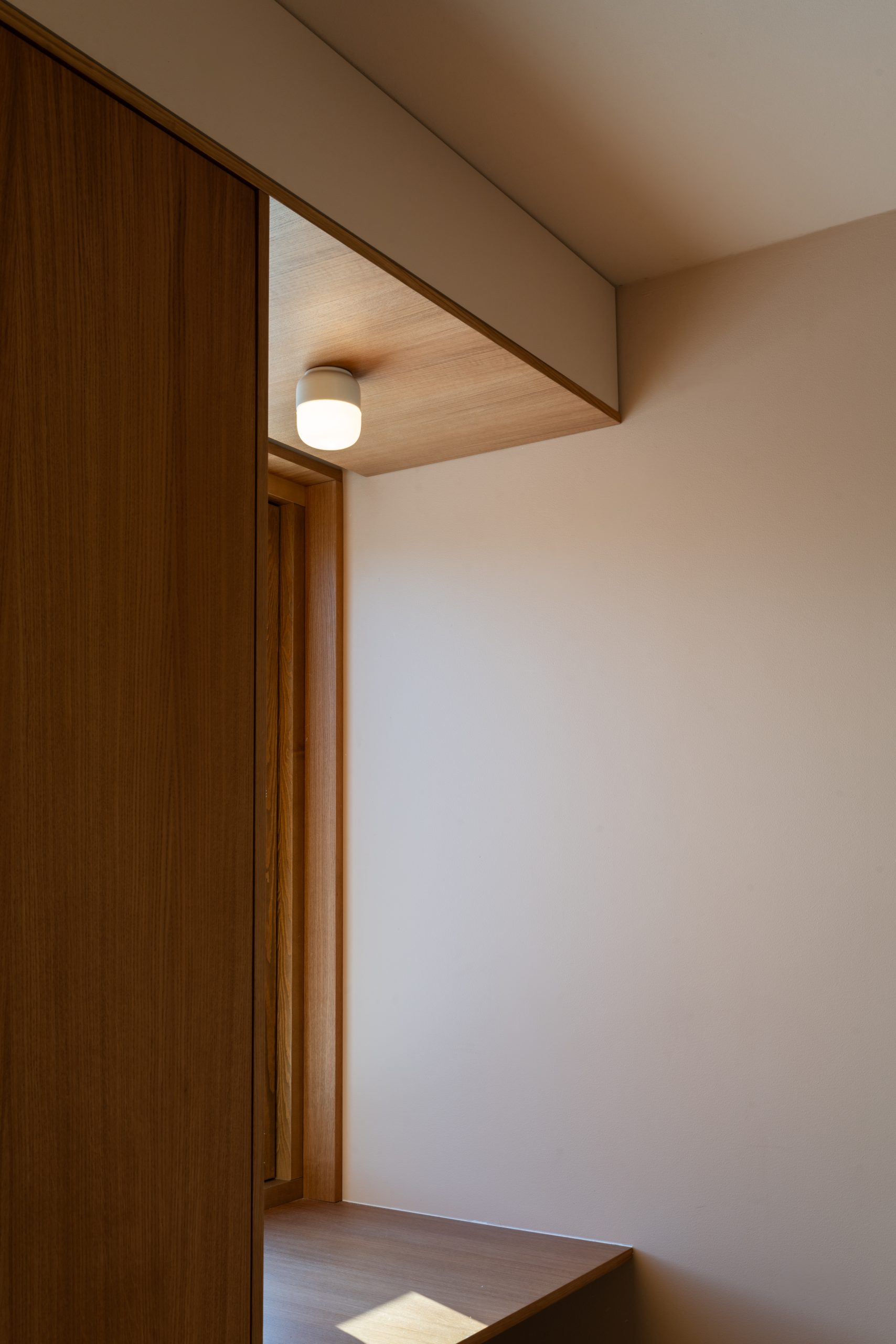 Moderne interiørdesign med trepanel og innebygd lys i et minimalistisk rom med vegger malt i Jotun 11173 Humble Yellow