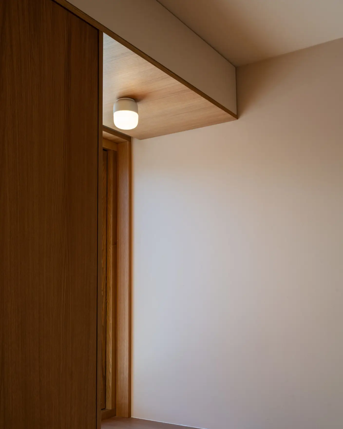 Moderne interiørdesign med trepanel og innebygd lys i et minimalistisk rom med vegger malt i Jotun 11173 Humble Yellow