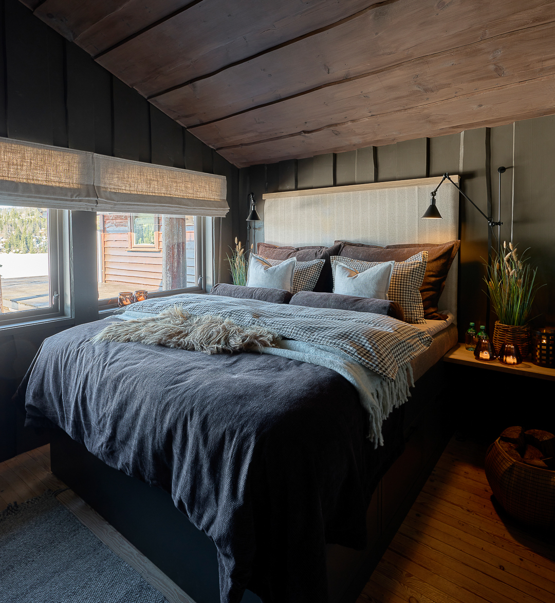 Soverom på hytte med mørk og lun hyttestemning, villmarkspanel på vegg malt i mørkegrå Jotun Evening Stone, tak beiset i jotun Mocca.