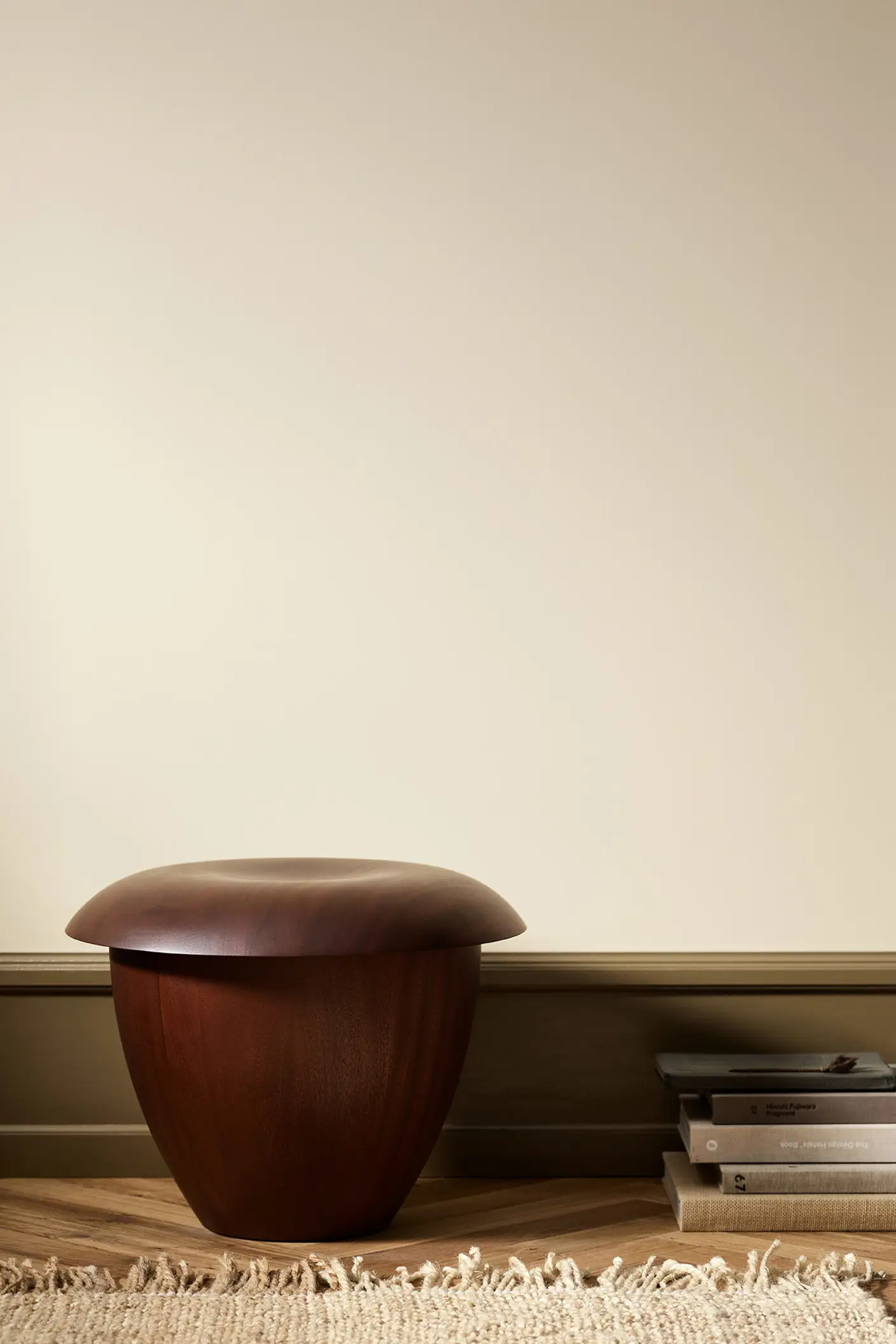 Wooden stool in a minimalist room with wall painted with Jotun 12313 Soft Dunes.