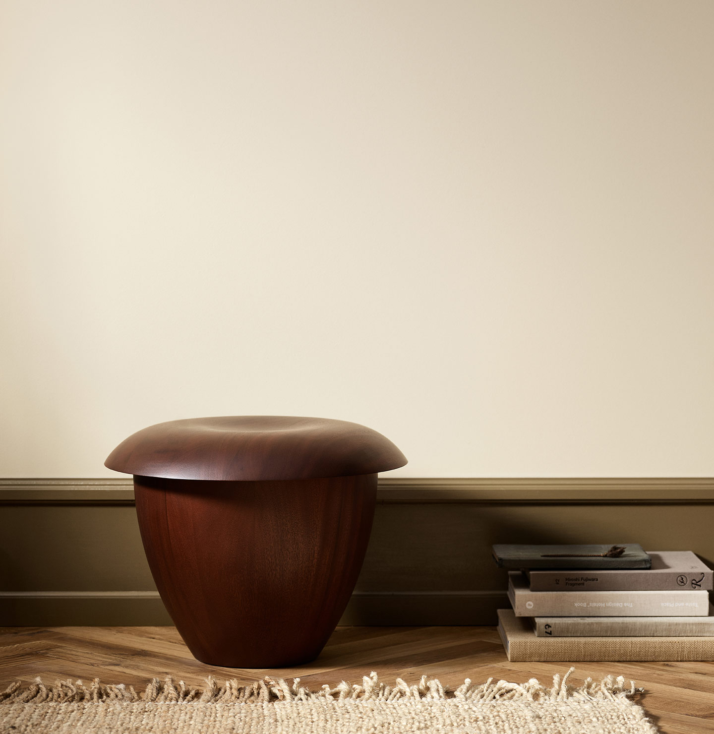 Wooden stool in a minimalist room with wall painted with Jotun 12313 Soft Dunes.
