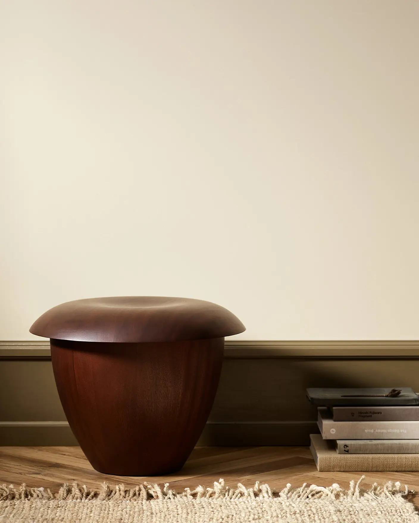 Wooden stool in a minimalist room with wall painted with Jotun 12313 Soft Dunes.