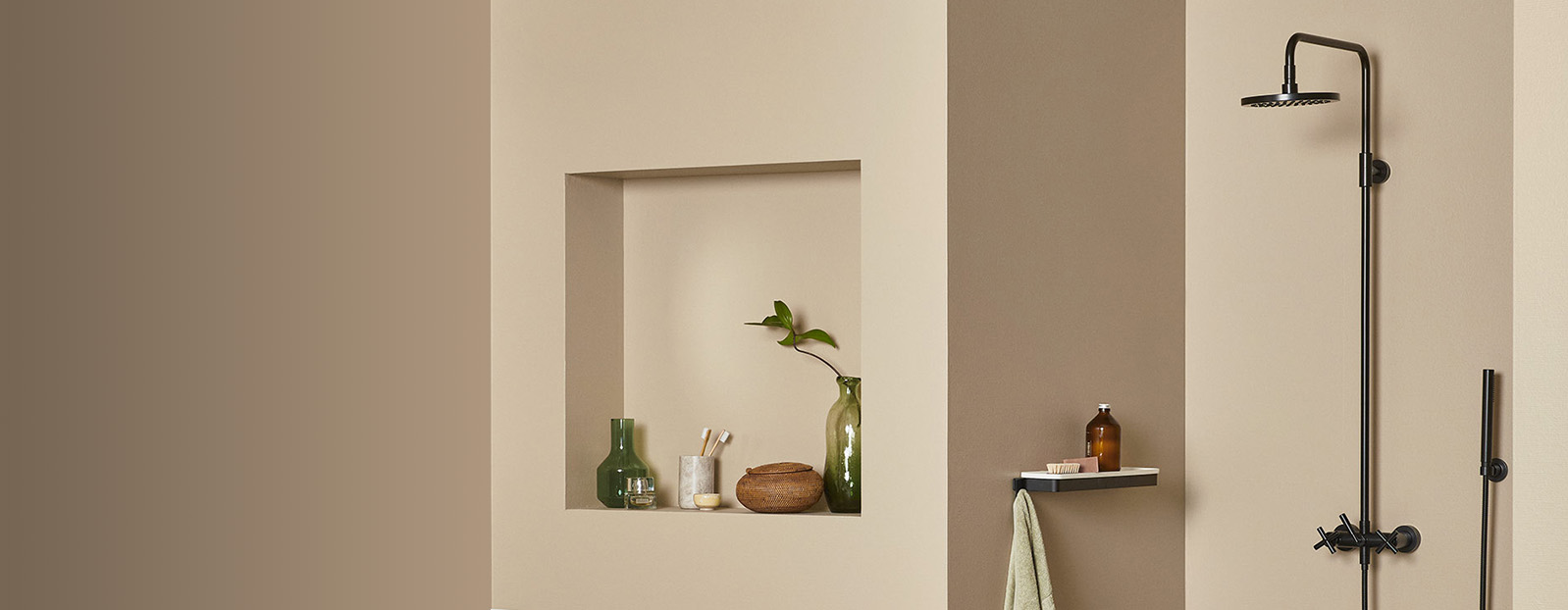 Moderne dusjinteriør med veggmontert, sort dusjarmatur, grønne planter og naturlige dekorasjoner på hyllen i minimalistisk stil