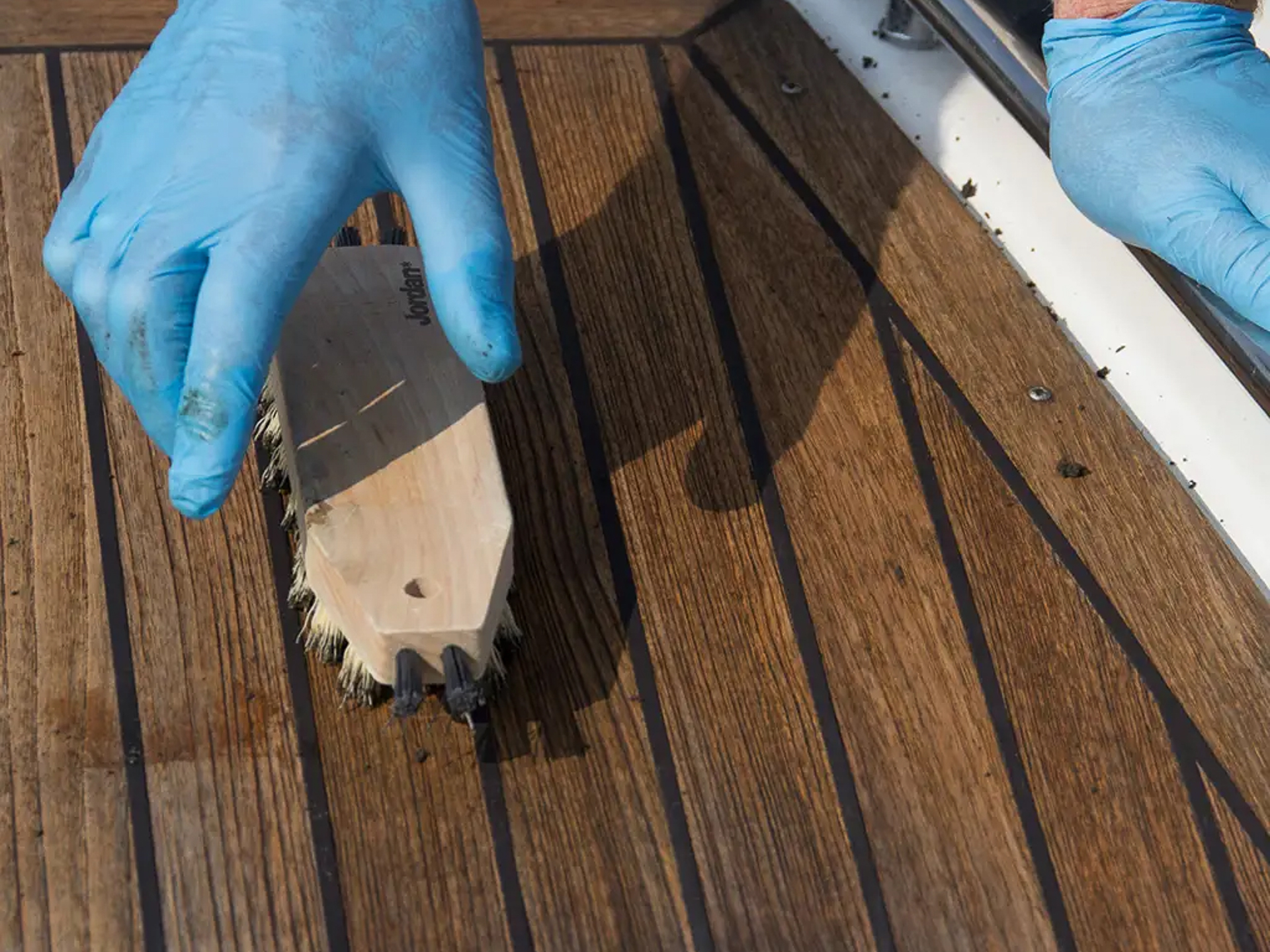 Vasking av teakdekk på båt med børste