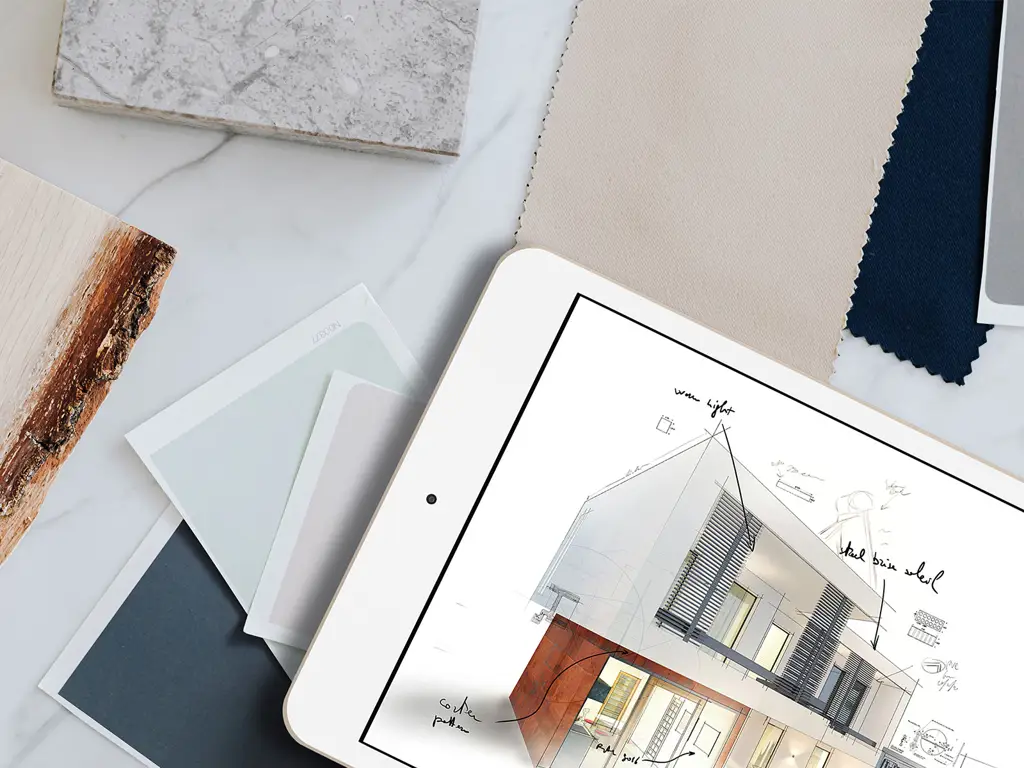 Interiørdesignbord med nettbrett som viser husillustrasjon, materialprøver og fargepalett for arkitekturprosjekt