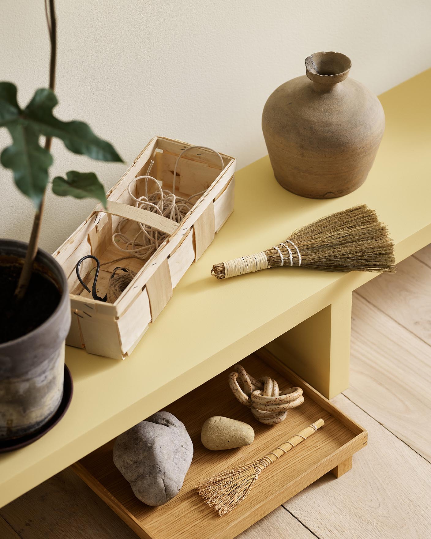A yellow bench in the Jotun colour 1965 Ginger Tea against a golden, white wall painted in 1625 Soul.