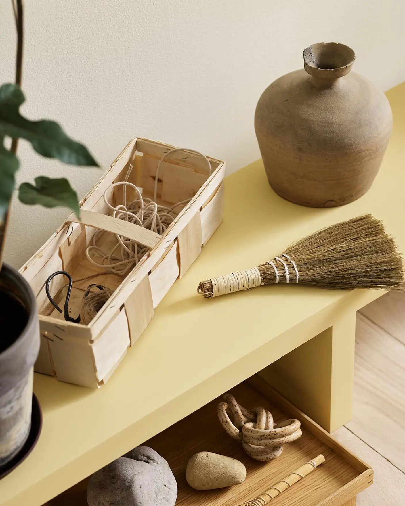 A yellow bench in the Jotun colour 1965 Ginger Tea against a golden, white wall painted in 1625 Soul.