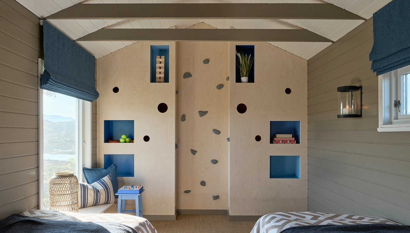 Anneks på hytte med klatrevegg og innebyggede hyller.