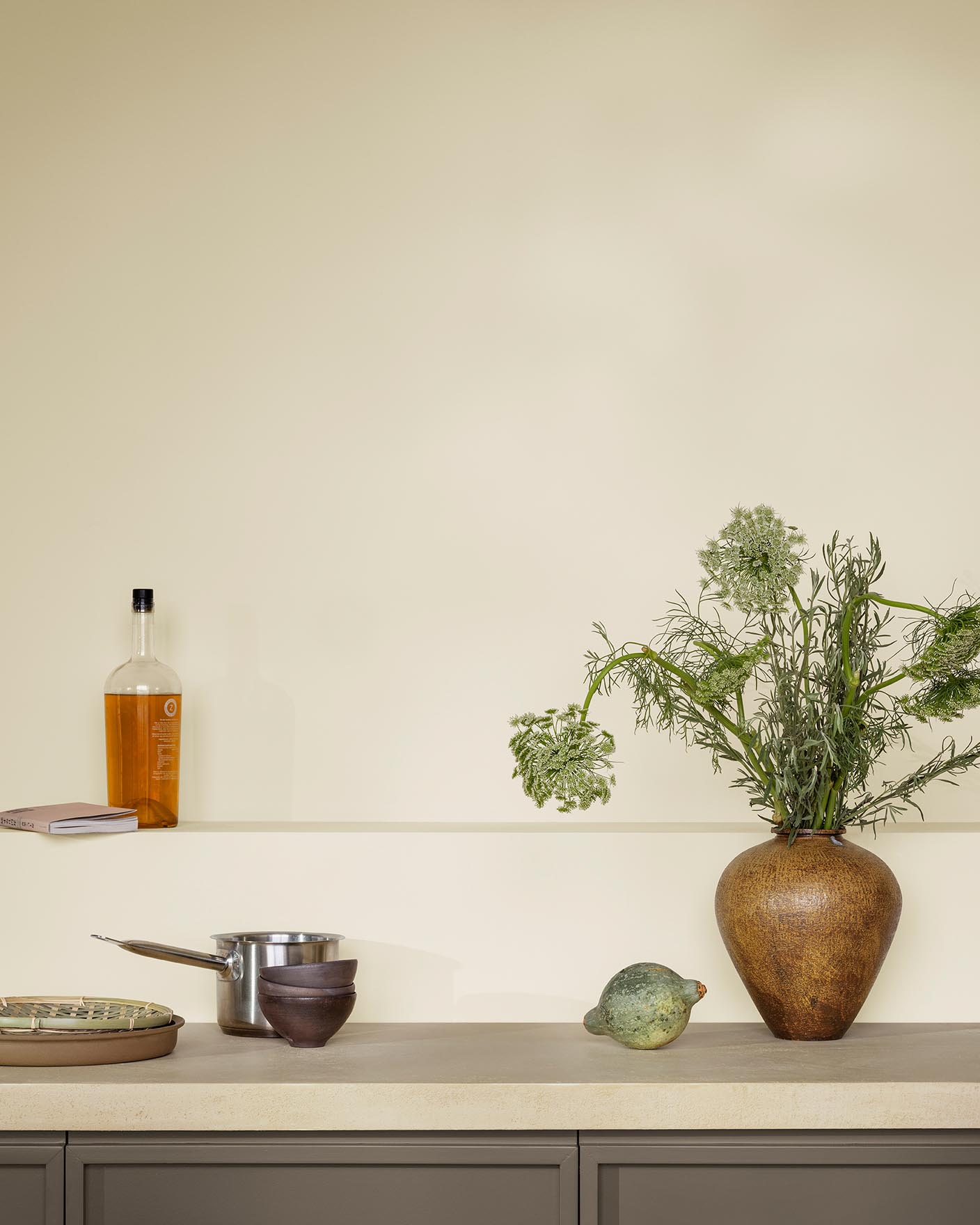 Dette kjøkkenet føles luftig og jordnært med sine gyllenbeige vegger malt med Jotun 1276 Soft og gyllenbrune skap i fargen 11012 Rustic Brown fra Jotun.