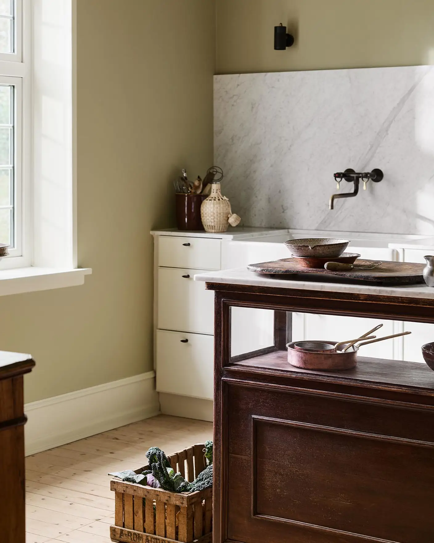 Kitchen with a marble backsplash, white cabins and a wooden island. Walls and ceiling painted with the Jotun colour 8284 Olive.