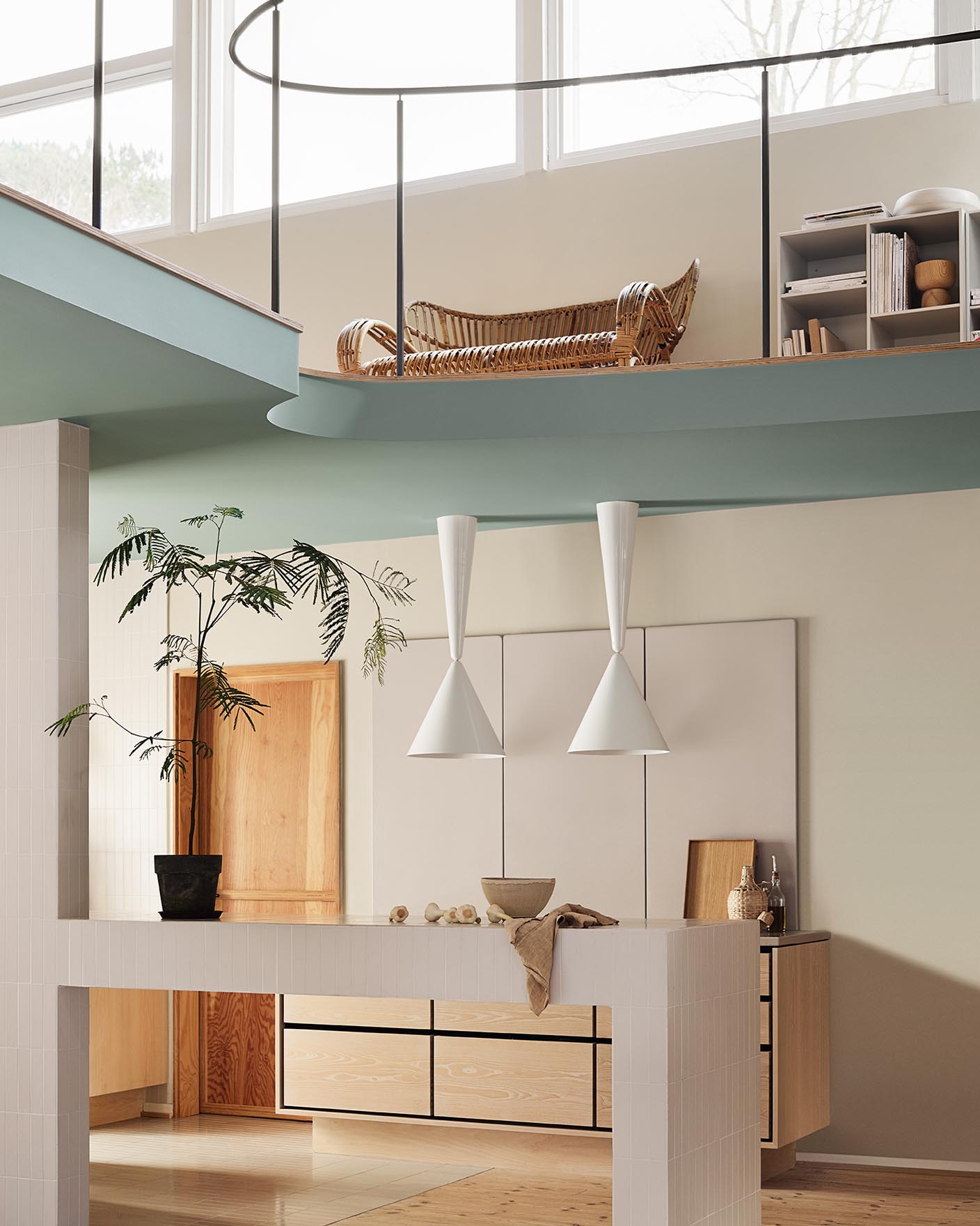 Modern interior with pendant lights and a loft area. Beige walls painted with the Jotun colour 12308 Unbleached. Loft area painted in the bluish green colour 6378 Iconic.