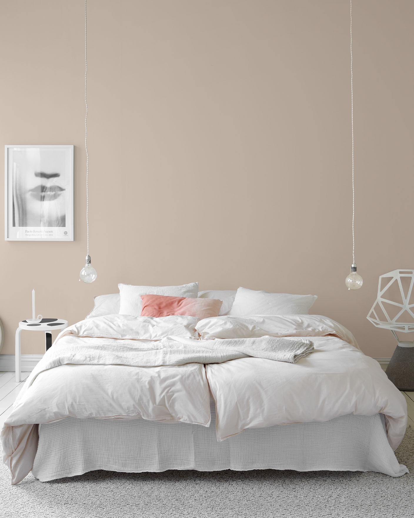 Lyst soverom med hvit seng, minimalistisk innredning og dempede, gyldenrosa vegger malt med Jotun 10580 Soft Skin.