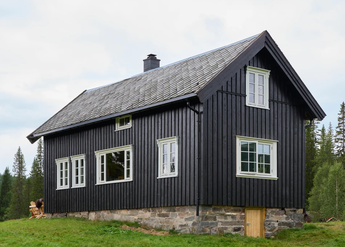 Hytte med skifertak malt i mørk brun, Seterbrun, Jotun DRYGOLIN, vinduer med sprosser og hvite karmer malt i Jotun Egghvit.