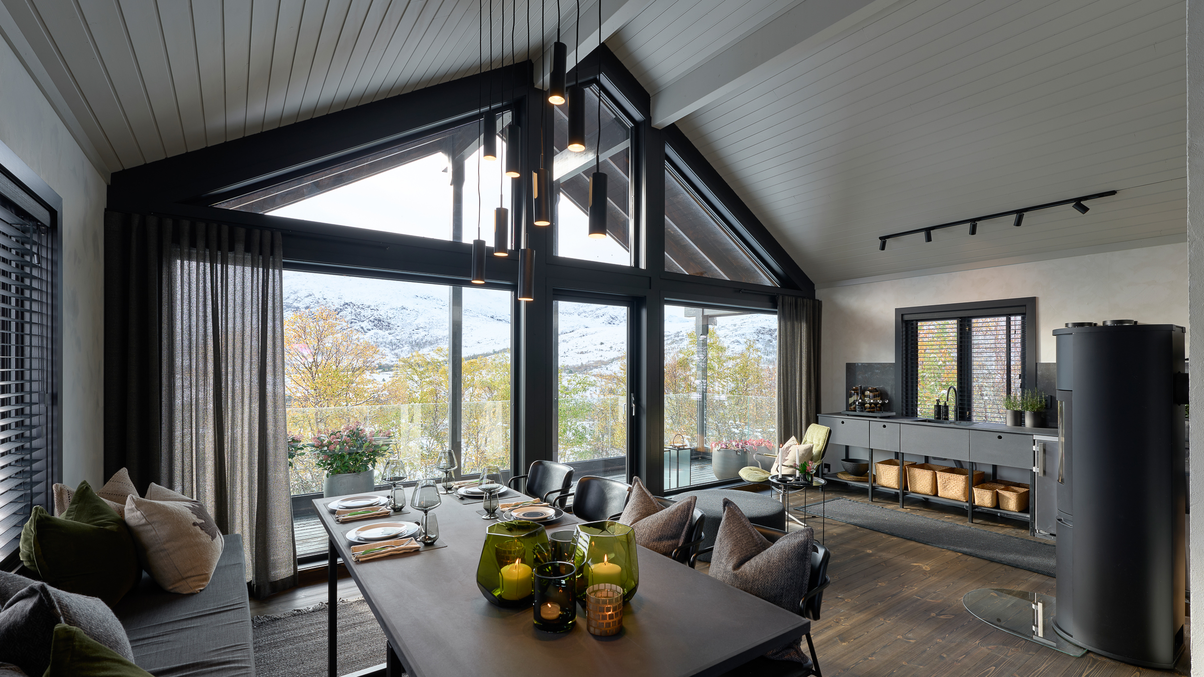 Utsikt gjennom nye store vinduer over hele endeveggen i hytte. 