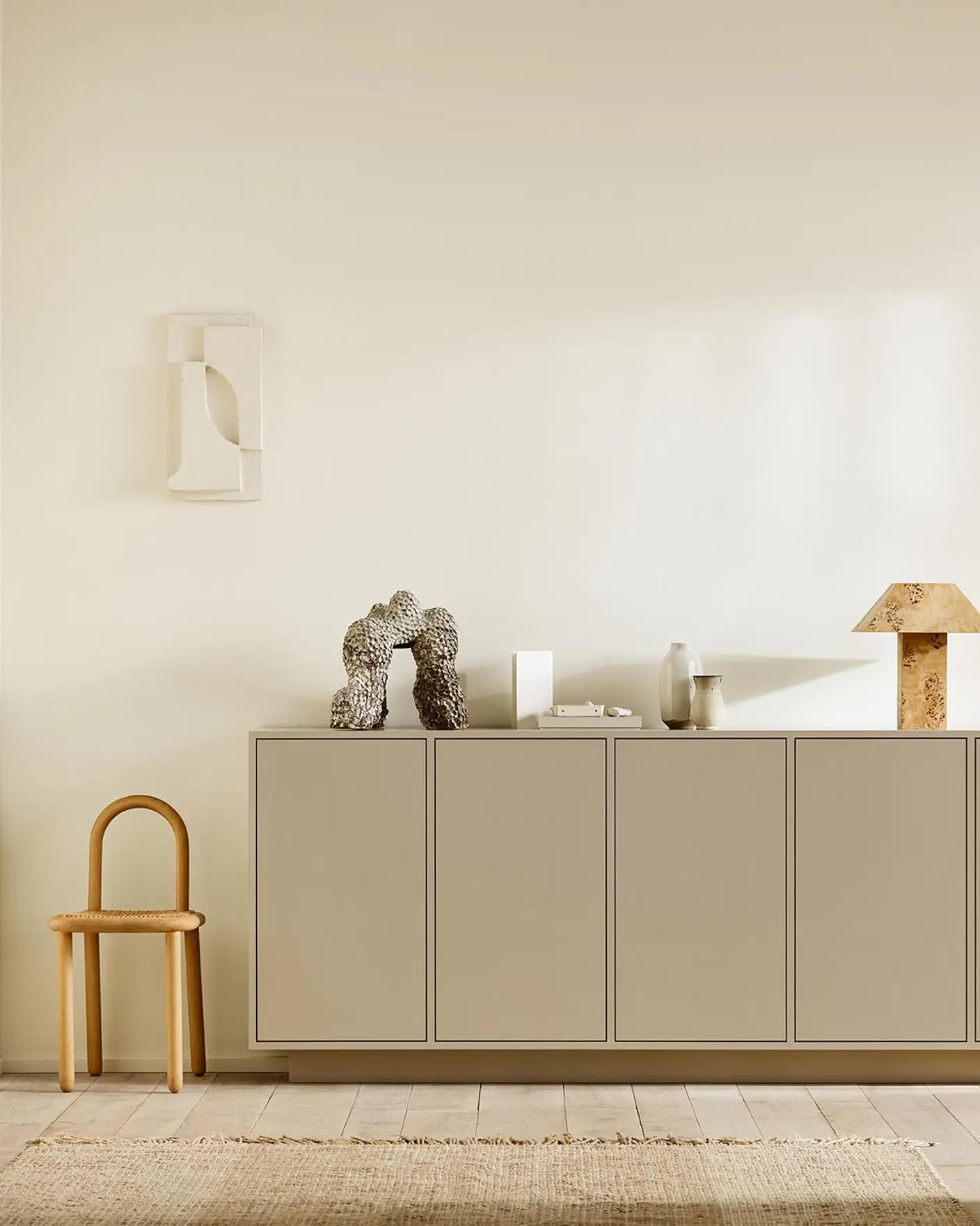 Minimalist interior with wooden chair, a cabinet painted with 12300 Hazelnut Beige against a beige wall painted in the colour Jotun 1625 Soul.