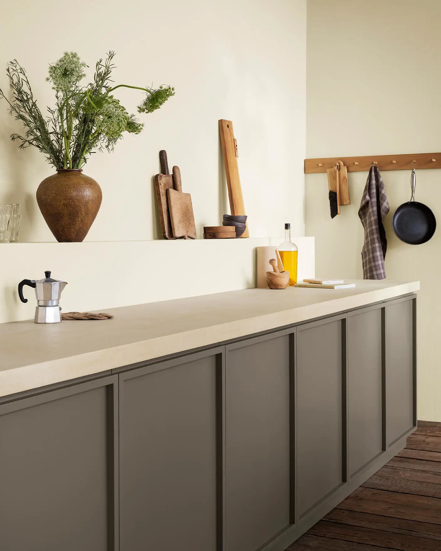 Dette kjøkkenet føles luftig og jordnært med sine gyllenbeige vegger malt med Jotun 1276 Soft og gyllenbrune skap i fargen 11012 Rustic Brown fra Jotun.